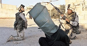 US troops humiliate a prisoner in Iraq