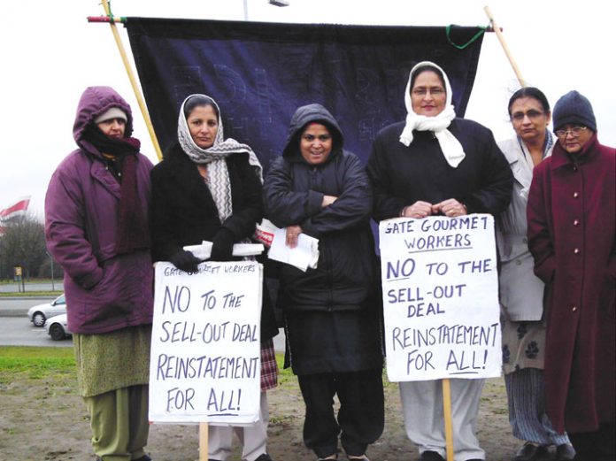 Locked-out Gate Gourmet workers on the picket line at the Beacon roundabout near the factory yesterday midday