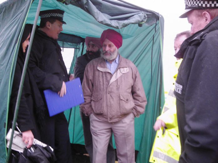 Duty Inspector Harrison tells Gate Gourmet TGWU branch secretary JARNAIL SINGH  that the tent must come down and the picket  on the hill must end