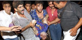 Palestinians carrying a badly injured  child as a result of an Israeli bombing of flats in Gaza