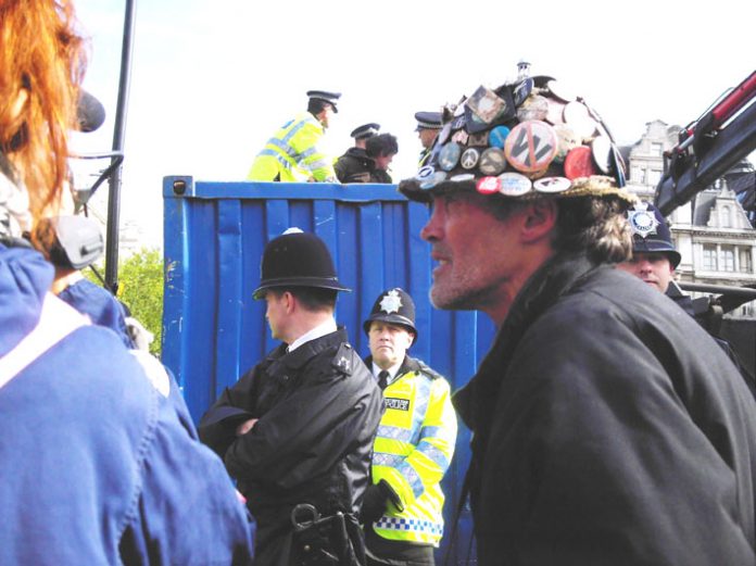 Parliament protester of 5 years BRIAN HAW, on Tuesday morning in front of a skip where all his documents and placards were thrown after a force of 50 police seized them in the early hours