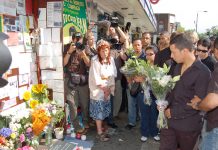 Alex Pereira (right) lays flowers at the shrine outside Stockwell station for his cousin Jean Charles de Menezes on the first anniversary of the young Brazilian man’s shooting by armed police on July 22, 2005