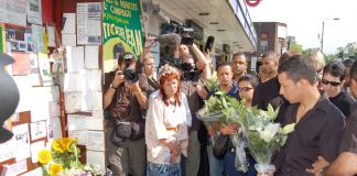 Alex Pereira (right) lays flowers at the shrine outside Stockwell station for his cousin Jean Charles de Menezes on the first anniversary of the young Brazilian man’s shooting by armed police on July 22, 2005