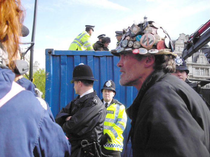 Police taking away the vast bulk of BRIAN HAW’S (right) posters and placards from Parliament Square in May last year