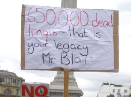 A demonstrator in London reminds Blair of the legacy that he brings as the new ‘Middle East envoy’