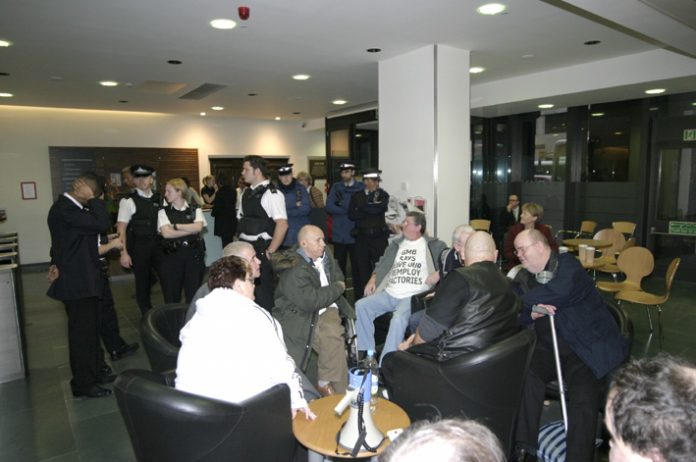 Remploy workers occupying the Department of Work and Pensions head office yesterday, surrounded by police. The protesters demanded that the 28 Remploy factories be kept open