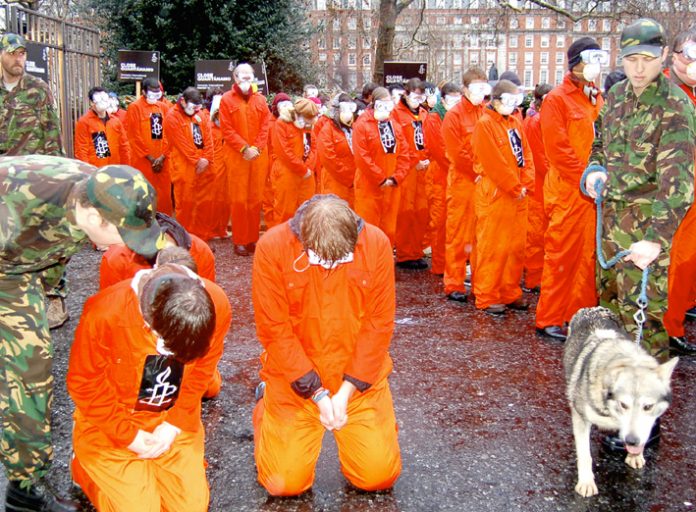 Hundreds of demonstrators yesterday re-enacted the humiliation of detainees by US troops at Guantanamo Bay, demanding the concentration camp’s immediate closure