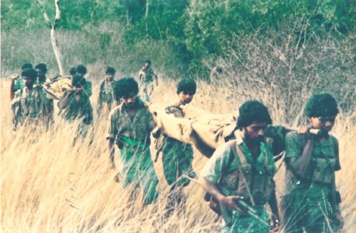 Tamil Tiger fighters carrying their wounded through the countryside