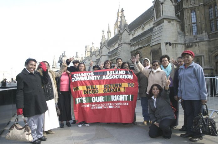 Chagossians with their Community Association banner, demanding the right to return to Diego Garcia, outside parliament yesterday