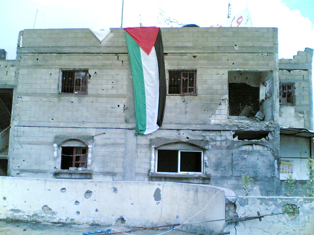 Palestinians fly their  flag in Beit Hanoun in defiance of Israeli army shelling of their homes