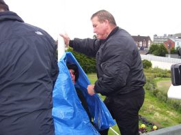 Council bailiffs wrap anti-academy protester HANK ROBERTS (who had D-locked himself on the roof) in a cover before using an angle grinder to release and evict him last Friday morning