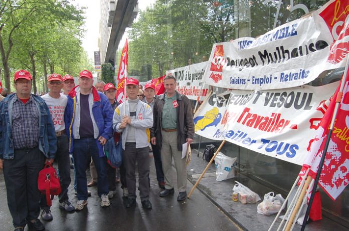 Peugeot workers lobby a shareholders meeting against factory closures in May 2006