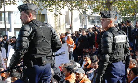 Tamil demonstrators sit down as French riot police stop them marching
