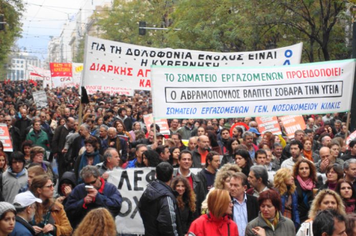 Greek workers marching through Athens during the nationwide revolt that continued into a third week yesterday