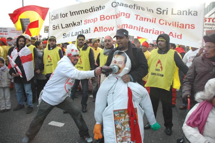 A Tamil marcher bashes an effigy of Sri Lankan President Rajapakse with his shoe – More than 120,000 Tamils and their supporters marched in London on Saturday to demand a halt to the shelling of Tamil areas in northern Sri Lanka and no more UK support for