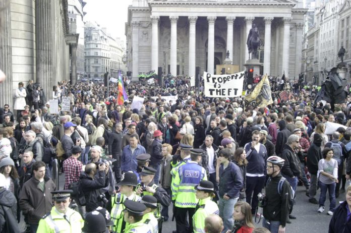 ‘Property is theft’ banner amidst thousands of protesters outside the Bank of England