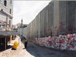 The land-grabbing Israeli separation wall looms over Abu Dis on the outskirts of Jerusalem