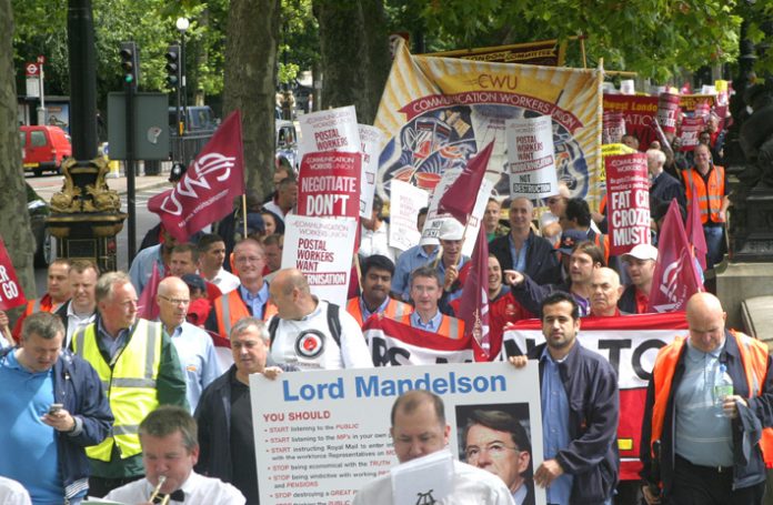 Postal workers marching along the embankment carrying a giant postcard to Business Secretary Mandelson demanding he stop destroying a great public service