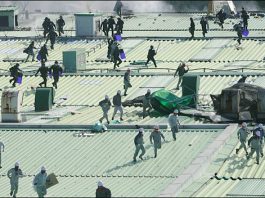 SSANGYONG WORKERS APPEAL FOR SUPPORT –under massive paramilitary attack Korean SWAT police team members landed onto the roof of the Ssangyong assembly line building chase workers occupying the building in defence of their jobs