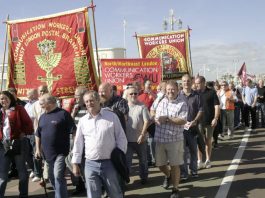 Postal workers march outside the Labour Party Conference urging the government not to back the break up of the industry