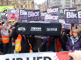Demonstrators with a coffin illustrating the blood price of the Iraq war