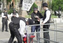 Armed police arrest and handcuff one of the peace protesters as they search his bag in Parliament Square yesterday morning