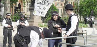 Armed police arrest and handcuff one of the peace protesters as they search his bag in Parliament Square yesterday morning