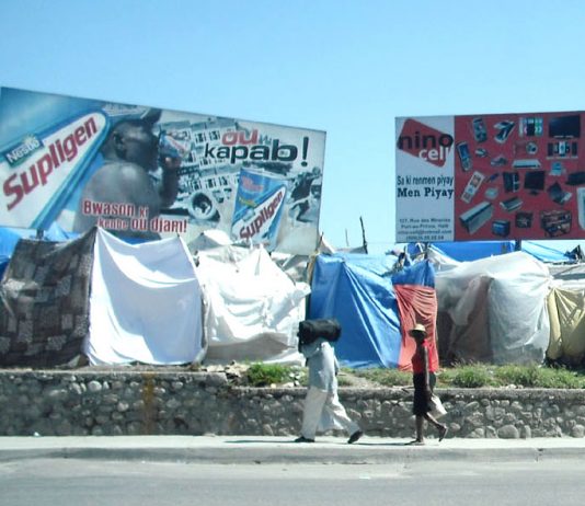 Haitians living in tents by the side of a main road