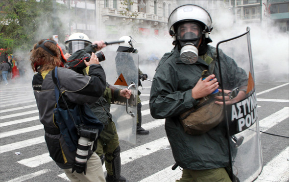 Riot police attack MARIOS LOLOS the President of the Greek Union of Press Photographers (EEF) outside the Vouli (Greek parliament) on 15 December.(Photo courtesy of EEF)