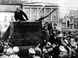 TROTSKY stands by as LENIN addresses a mass meeting in Petrograd