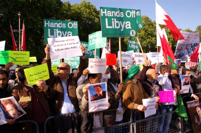 Libyan workers and youth gather outside Buckingham Palace to demand of the Queen and Obama that their forces quit Libya
