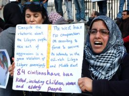 ‘DEAD OR ALIVE AL-HUMAYDI IS A HERO’ says Gadaffi Woman holds her own detailed placard on a protest over the war on Libya earlier this year