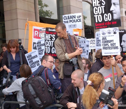 Demonstrators outside yesterday’s hearings where MPs questioned the Murdochs and sacked police chiefs, demanding that Cameron and Murdoch go
