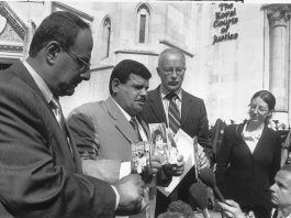 Baha Mousa’s father Daoud Mousa (centre) holds up photographs of his son’s children outside the High Court in London. He has fought a long-running legal battle to get justice for his son