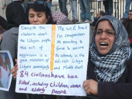 A demonstrator holds a detailed placard at a picket outside Downing Street earlier this year