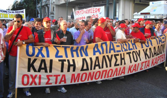 A section of demonstrating taxi drivers with their banner stating ‘No to the monopolies and cartels’