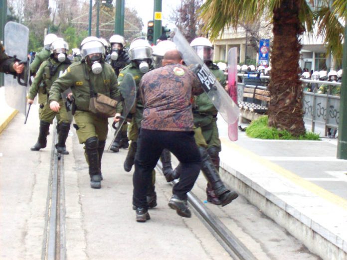 Worker in Athens stands his ground against a riot police attack