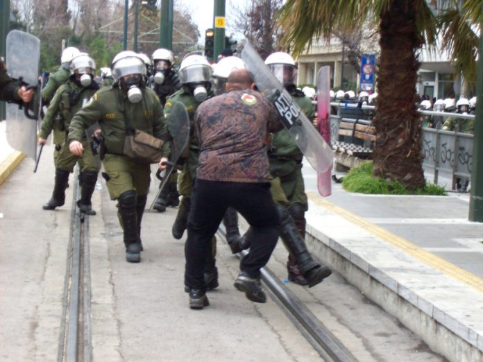 Greek worker stands his ground against an attack by riot police