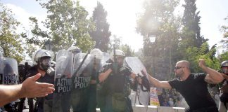 Greek worker takes on riot police during 120,000-strong march in Athens on Thursday’s general strike