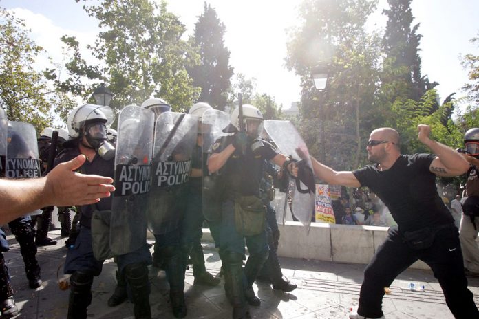 Greek worker takes on riot police during 120,000-strong march in Athens on Thursday’s general strike