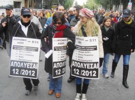 Three Social Services Institute (IKA) workers carrying placards pointing out that they were hired on 5/11 of this year only to be made redundant this month