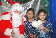 Father Chrismas with two young children at the Young Socialists Xmas Bazaar – many children will be going without this Christmas