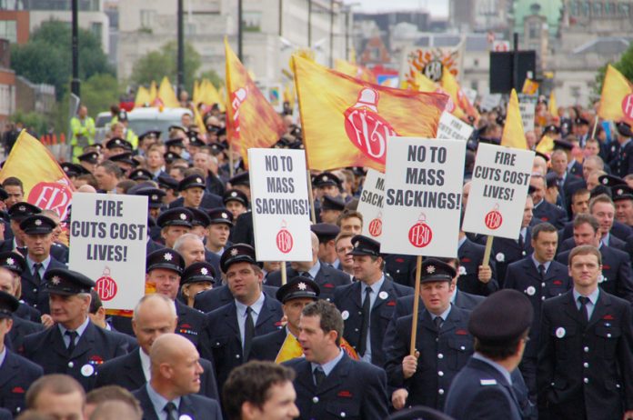 Firefighters marching in London with a current message that the fire service must be defended otherwise lives will be lost
