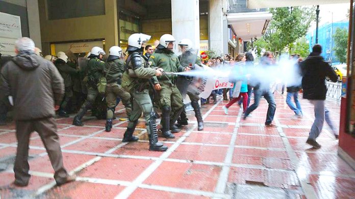 Riot police attack with tear gas spray gun a protesting student outside the central Athens office of the Finance Ministry’s Secretary on Thursday. Photo courtesy left.gr