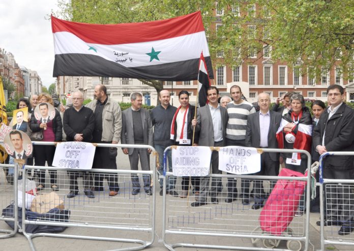 Syrians demonstrate outside the US embassy in London in support of President Assad against the imperialist support for terrorist acts in Syria