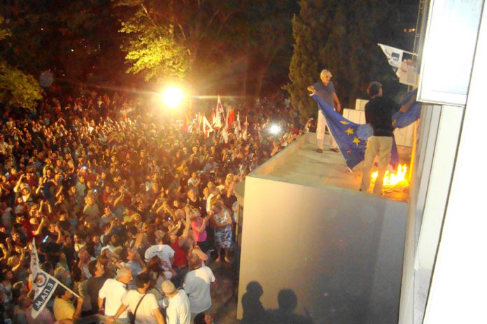 Workers setting a European Union flag on fire at the ERT building in Athens