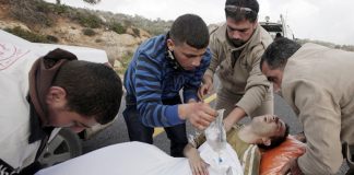 Young Palestinian injured after an attack by Israeli forces is treated for his injuries