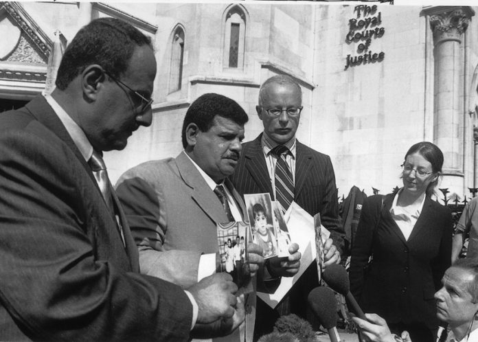 PHIL SHINER of Public Interest Lawyers outside the High Court, standing behind DAOUD MOUSA, seen holding pictures of his son, Baha and his family. Baha was beaten to death by British troops in Basra