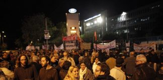 Workers outside the ERT’s gate on Thursday morning who responded to the call from the occupiers that they were under attack before they were violently pushed away by riot police Photo credit: Dromographos