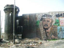 ISRAELI SETTLEMENT EXPANSION AND KILLINGS HAVE SCUPPERED NEGOTIATIONS – says Erekat Portrait of Yasser Arafat on the Israeli separation wall